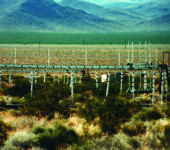 Rows of instrument platforms with scrubland in front and mountains behind.